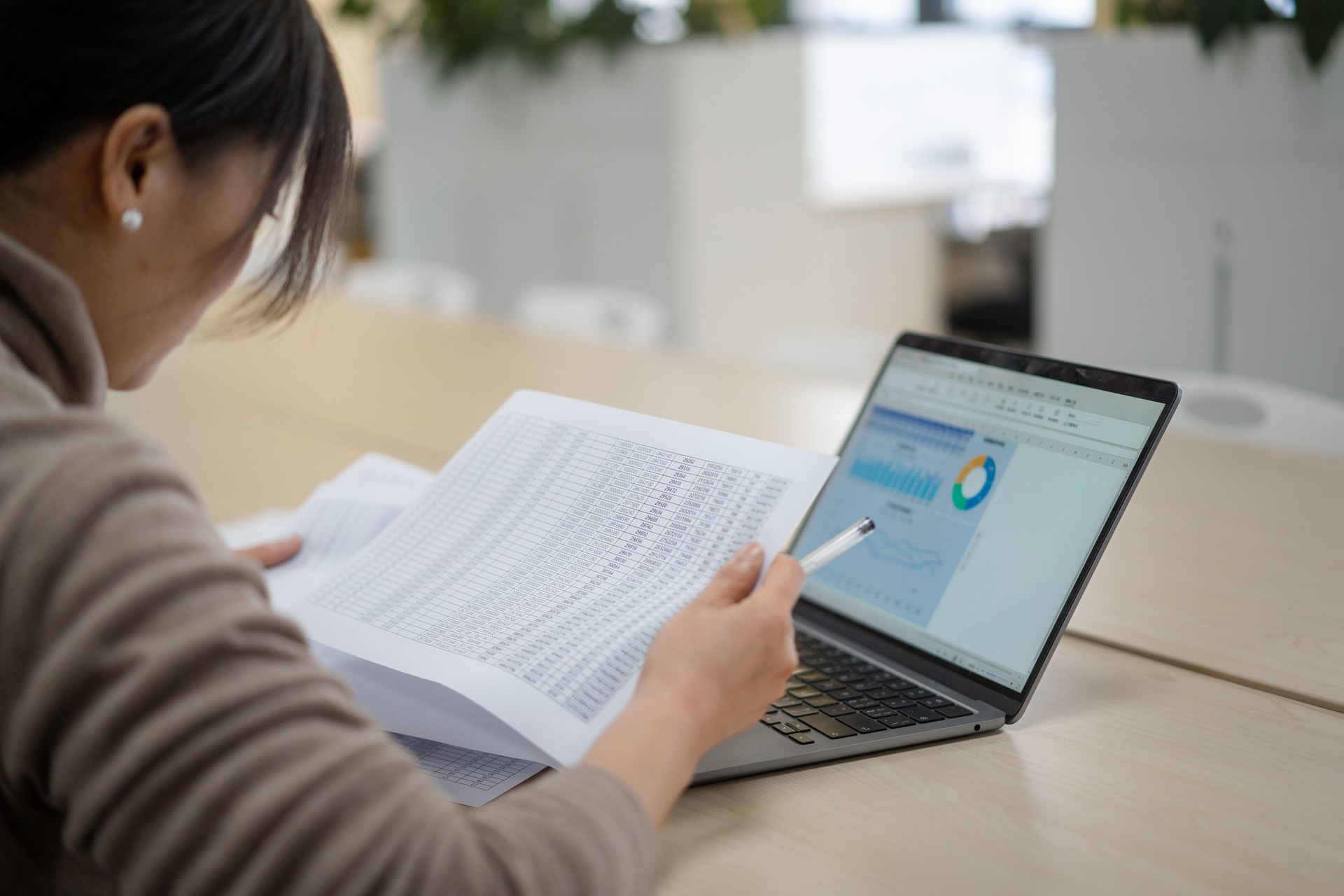 asian businesswoman Reviewing Paper Financial Statements